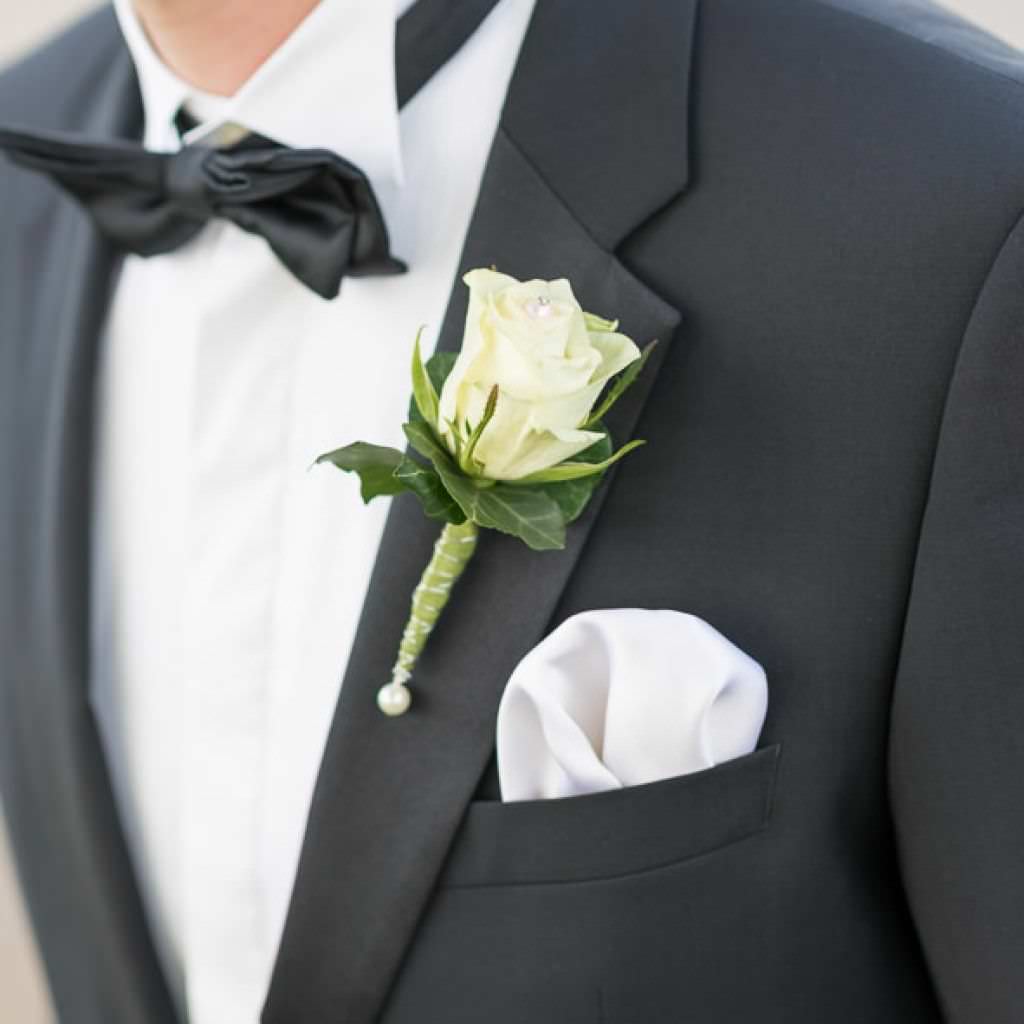 Klassischer dunkler Hochzeitsanzug mit weißer Rose als Boutonniere bei einer Hochzeit im Romantik Hotel Platte.