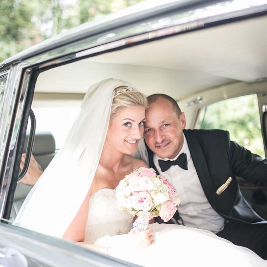 Das Brautpaar einer Hochzeit in der Bayer Villa kommt in einer Limousine angefahren.