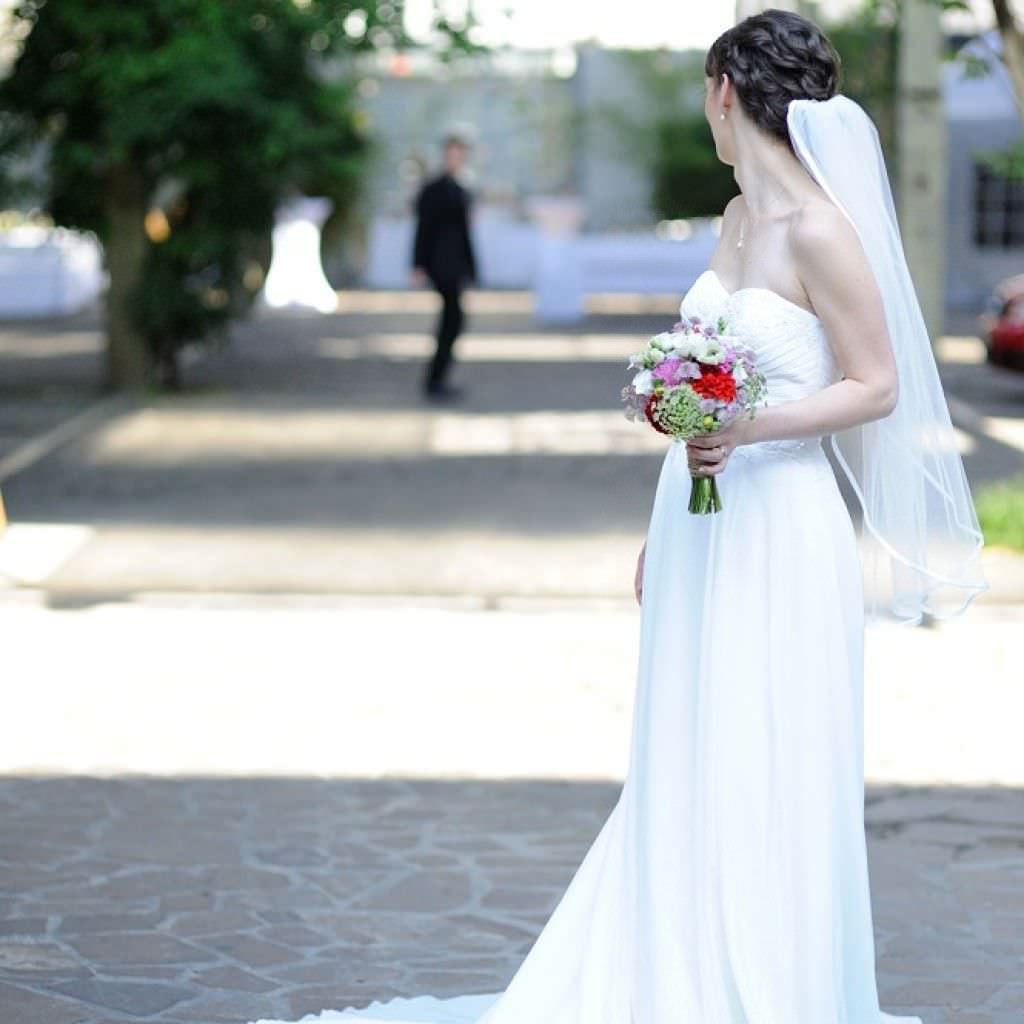 Die hübsche Braut in einem schulterfreien Brautkleid bei ihrer Vintage Hochzeit in Köln.