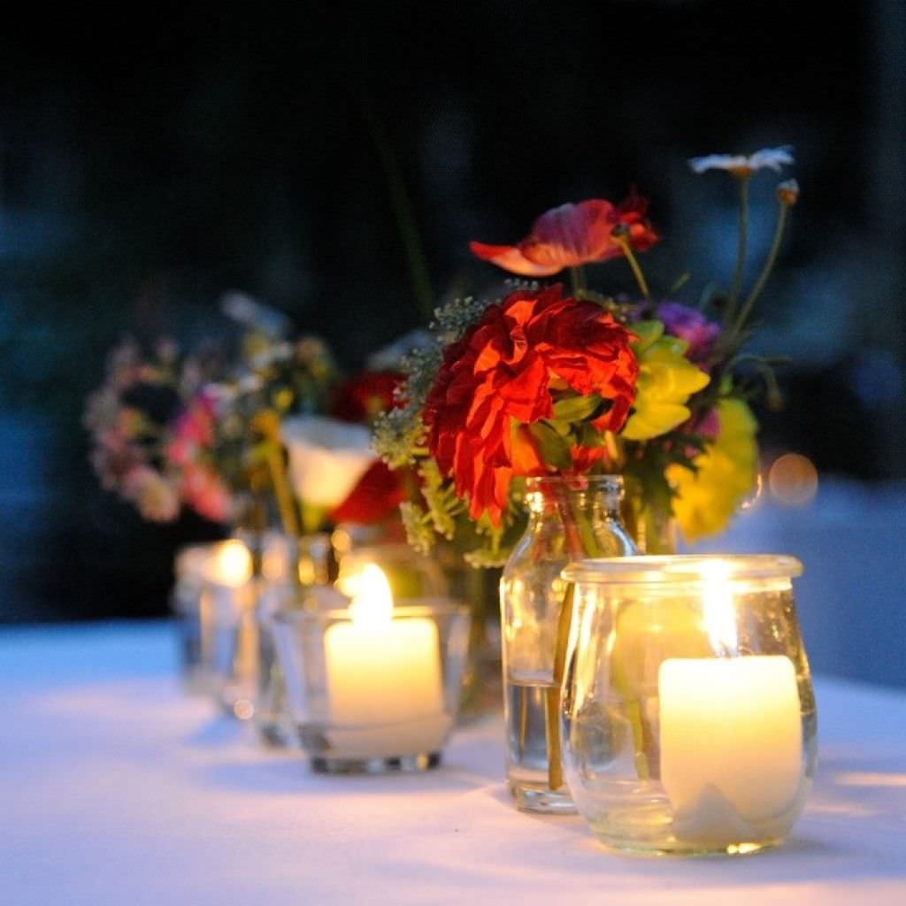 Hochzeitsdeko mit kreativer Floristik und romantischen Kerzen bei einer Vintage Hochzeit in Köln.