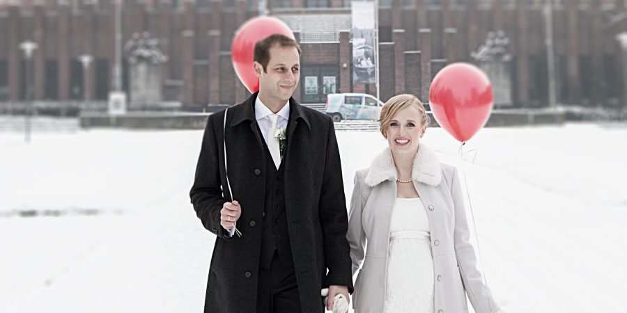 Das glückliche Brautpaar einer Winterhochzeit posiert im Schnee für Paarbilder.