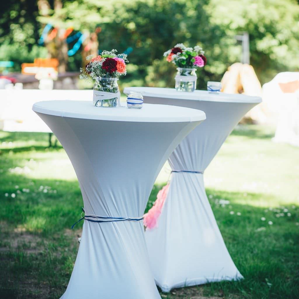 Dekorierte Stehtische bei einer Outdoor Sommerhochzeit auf dem Bauernhof.