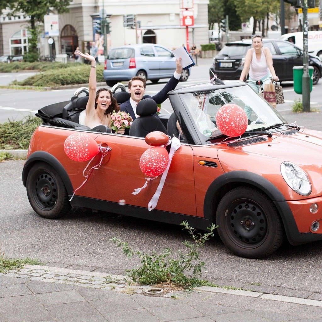 Braut und Bräutigam im Hochzeitsauto bei ihrer Traumhochzeit auf Schloss Meierhof.