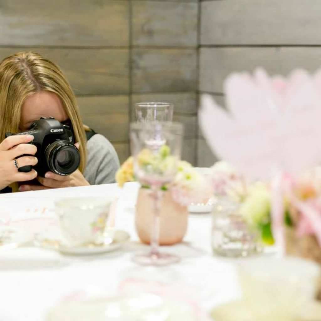 Eine Fotografin fotografiert einen gedeckten Hochzeitstisch auf dem 1. Deutschen Hochzeitskongress 2014.