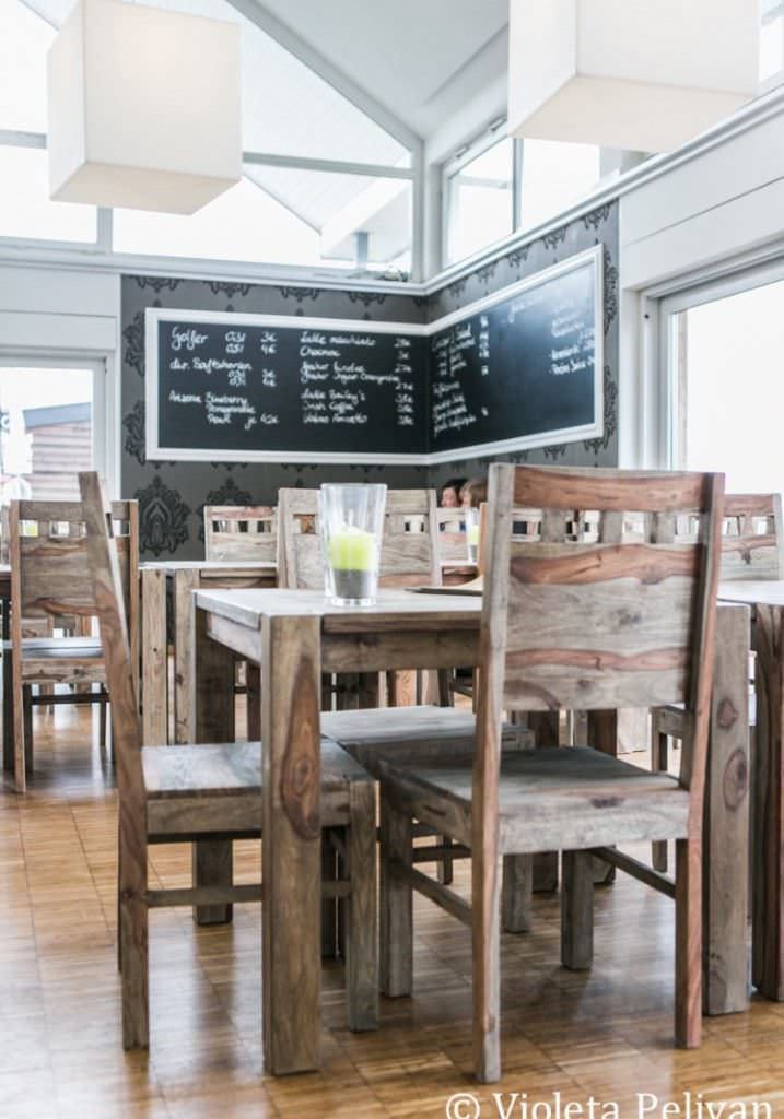 Menütafel und rustikale Holztische und Stühle in der Hochzeitslocation Trüffelschwein bei Düsseldorf.