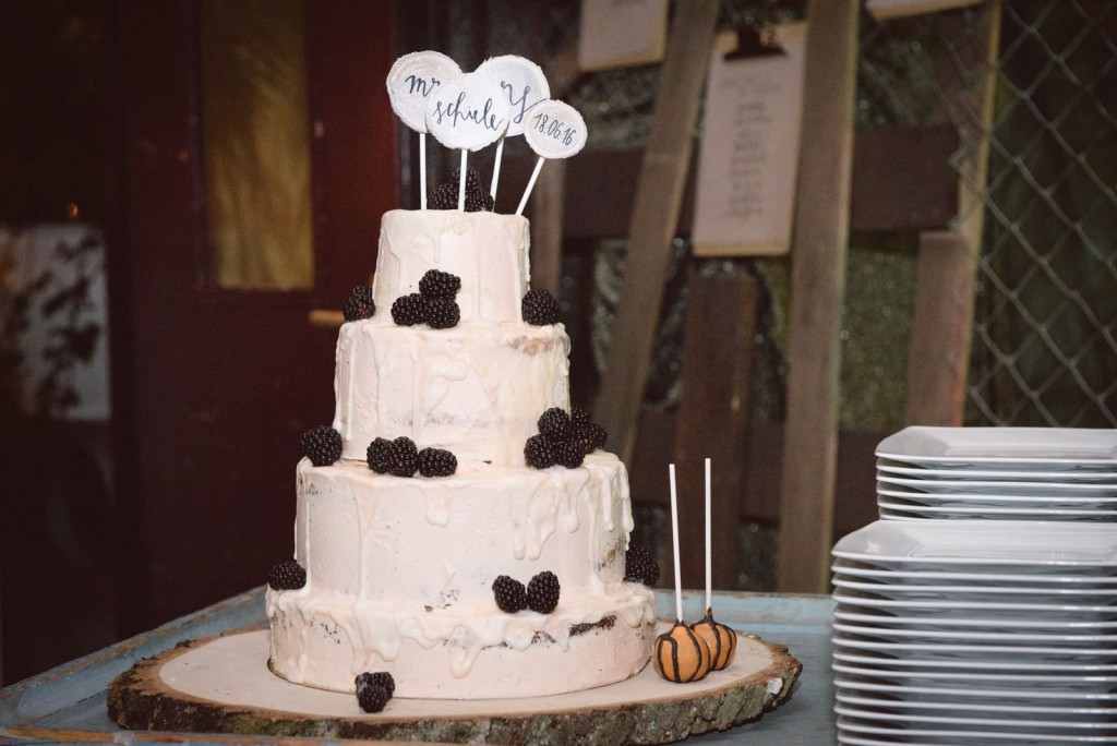 Weiße Drip Hochzeitstorte mit Brombeeren und Cake Toppern
