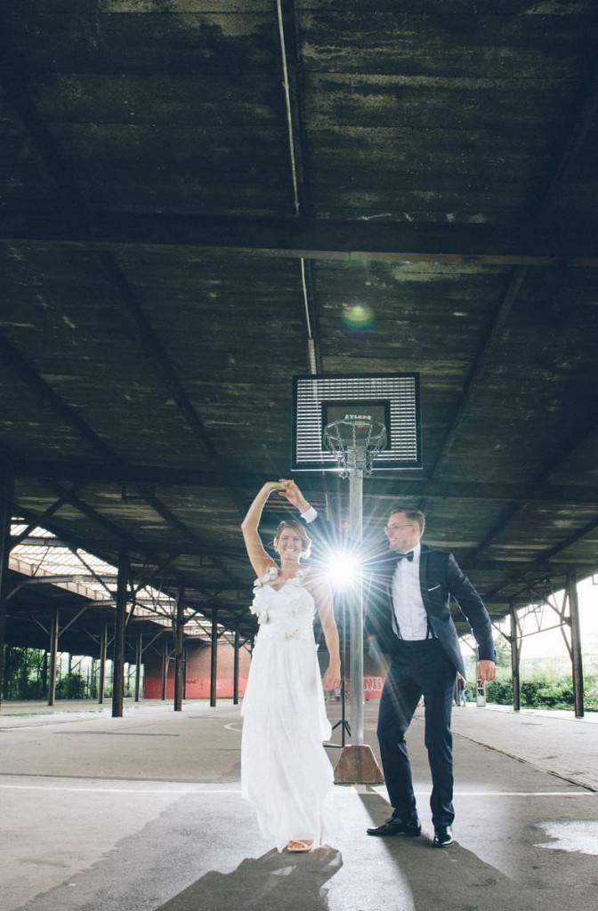 Hochzeitsfotoidee: Das Brautpaar tanzt unter einem Basketballkorb