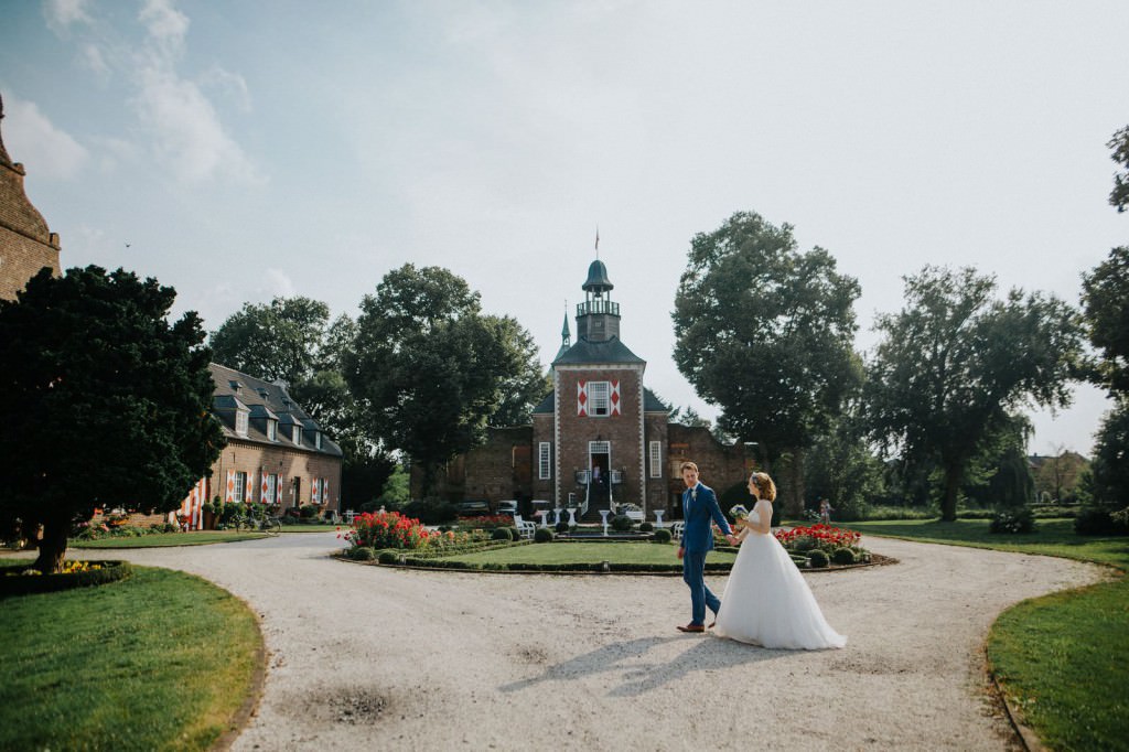 Brautpaar vor der Hochzeitslocation Schloss Hertefeld in Weeze