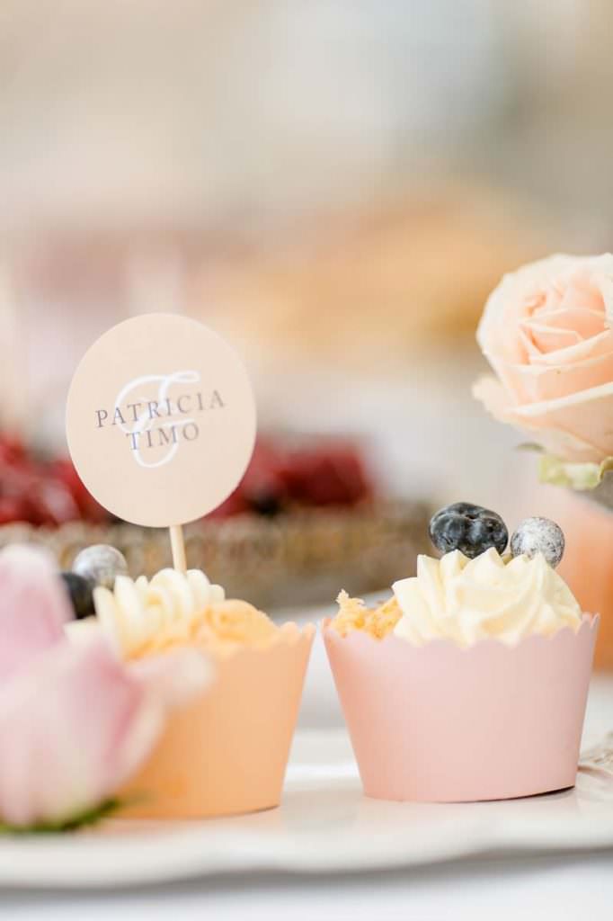 Cupcakes mit Creme und Topper auf dem Sweet Candy Table einer Hochzeit