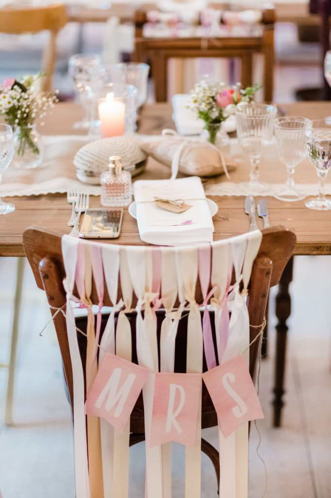 Hochzeit Gut Knittkuhle: Holzstühle mit Bänderdeko