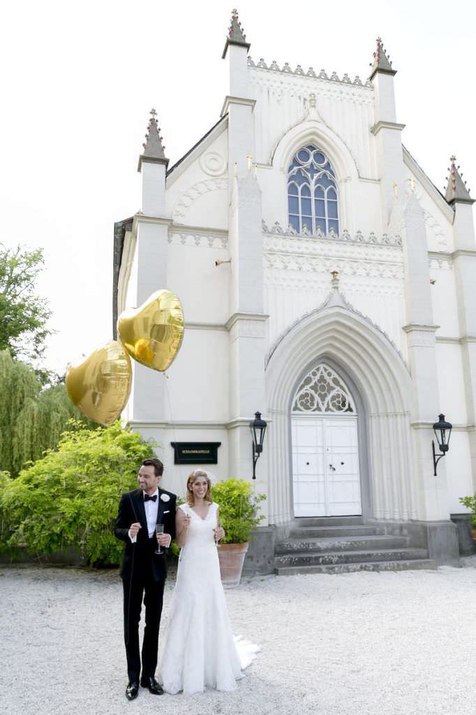 Hochzeit Schloss Gartrop: Paarfoto mit goldenen Herzluftballons
