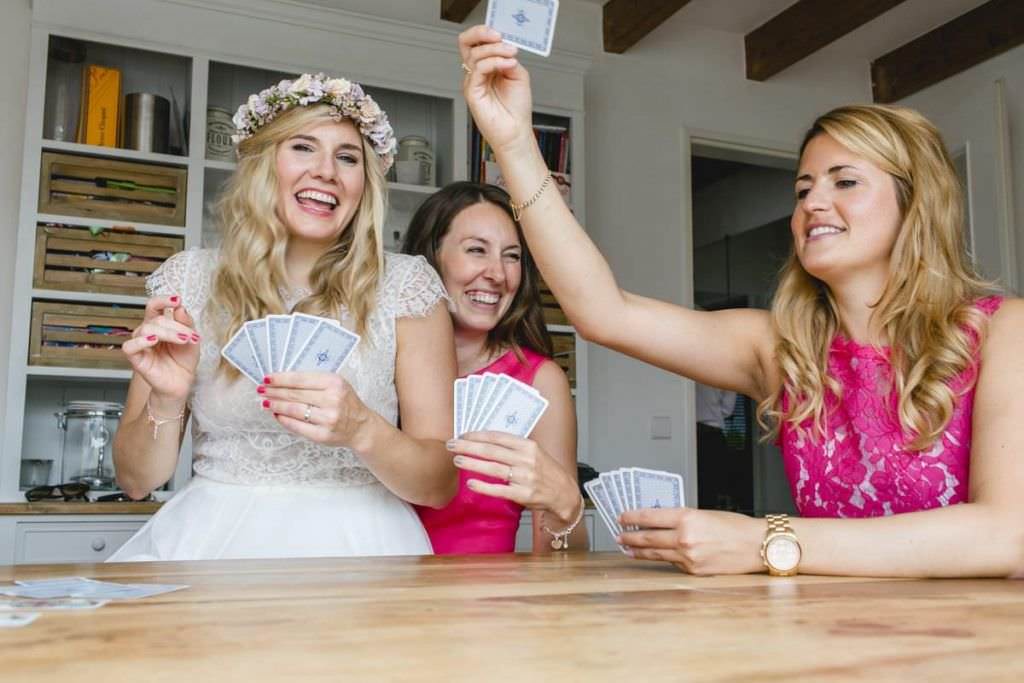 Hochzeit Kastanienhof Köln: Die Braut spielt mit ihren Brautjungfern Karten