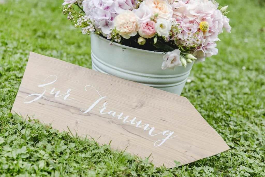 Hochzeitsdeko: Rustikales Wegweiser-Schild aus Holz mit der Aufschrift Zur Trauung