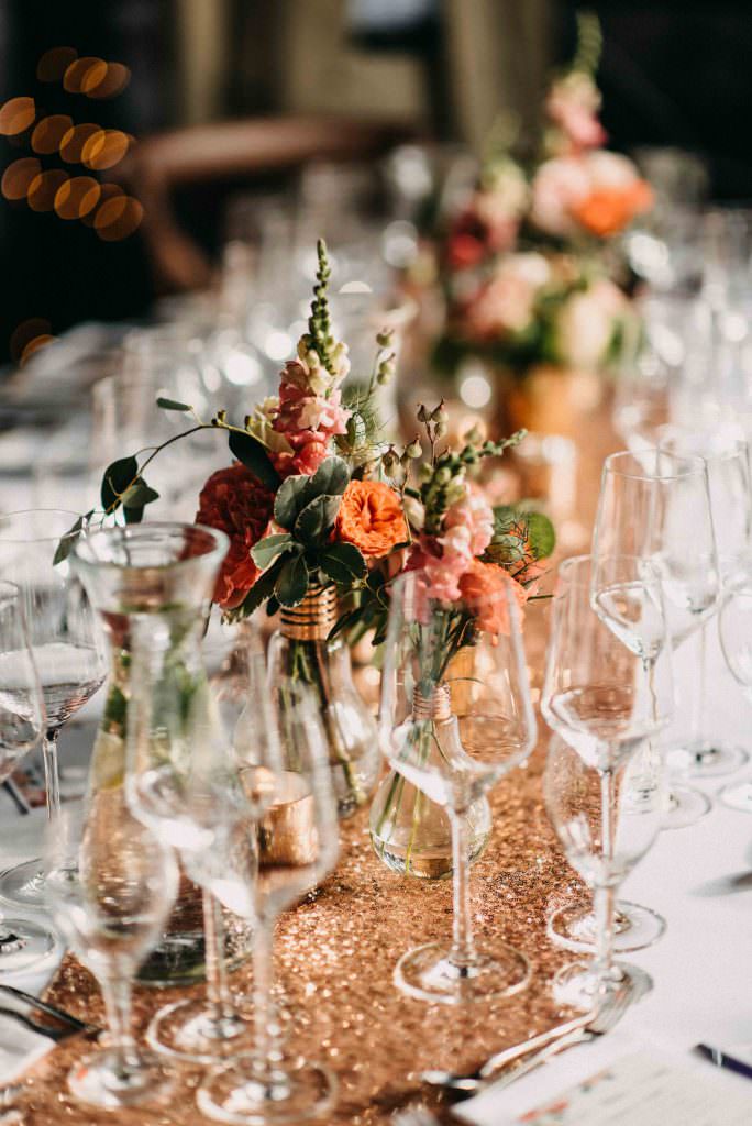 Hochzeitstischdeko mit Vasen in Glühbirnenform und Blumen in Orange und Rosa