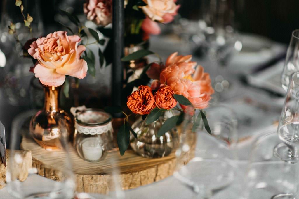 Hochzeitstischdeko mit Baumscheibe, Spitze und Blumen in Orange