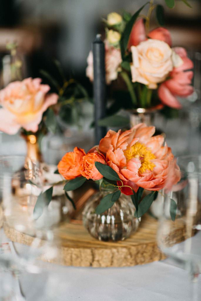 Hochzeitsblumen in Orange als Tischdeko bei einer Landhochzeit