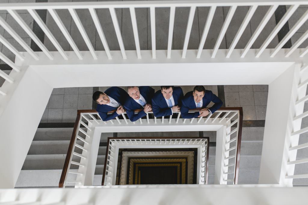 Originelles Hochzeitsgruppenfoto vom Bräutigam und seinen Groomsmen im Treppenhaus