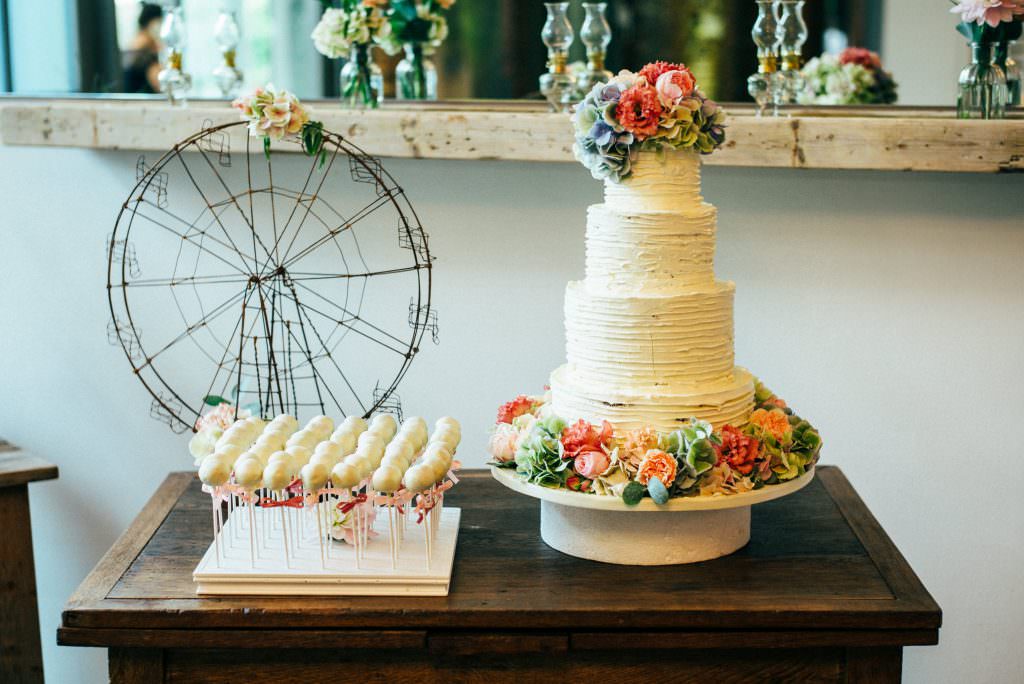 Weiße Hochzeitstorte mit zauberhafter Blumendeko und weißen Cake Pops