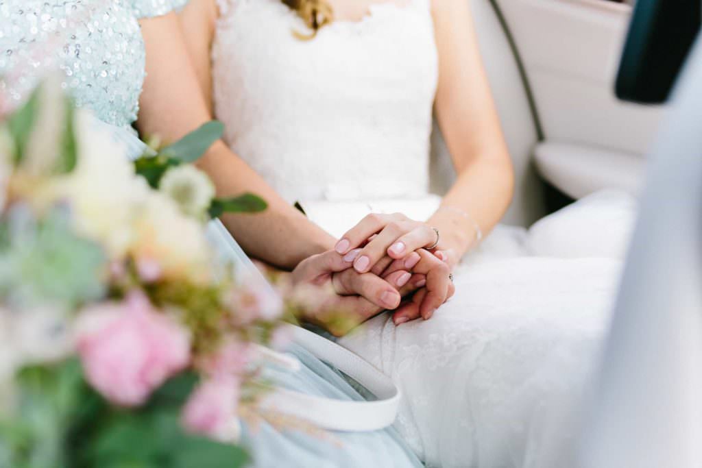 Das Brautpaar hält während der kirchlichen Trauung Händchen