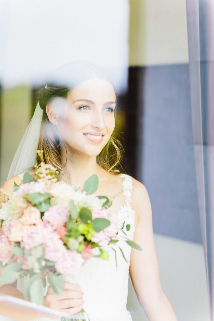 Hochzeit Gut Nettehammer: Brautportrait mit Blumenstrauß und Schleier