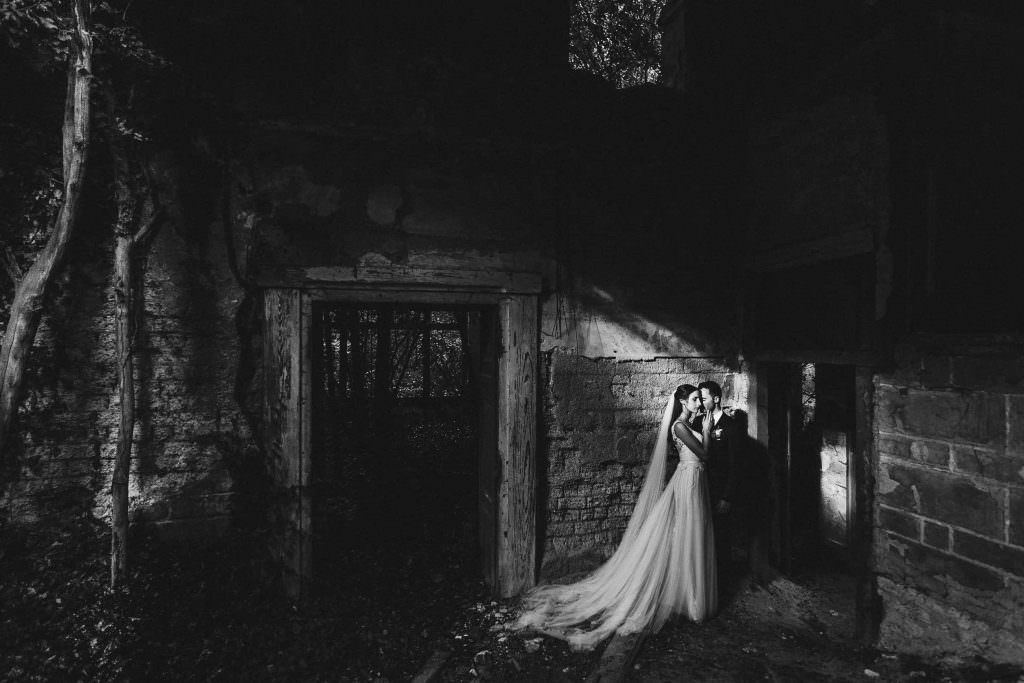 Kreatives schwarz-weiß Paarfoto von Braut und Bräutigam in einer alten Ruine