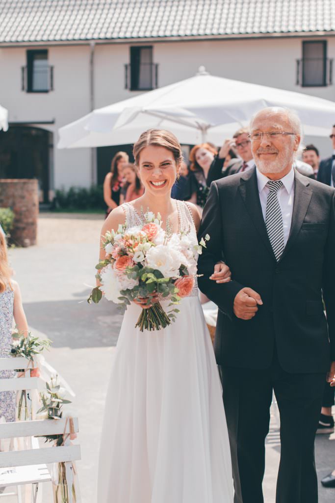 Gut Hohenholz Hochzeit: Die Braut wird von ihrem Vater zur Trauung geführt