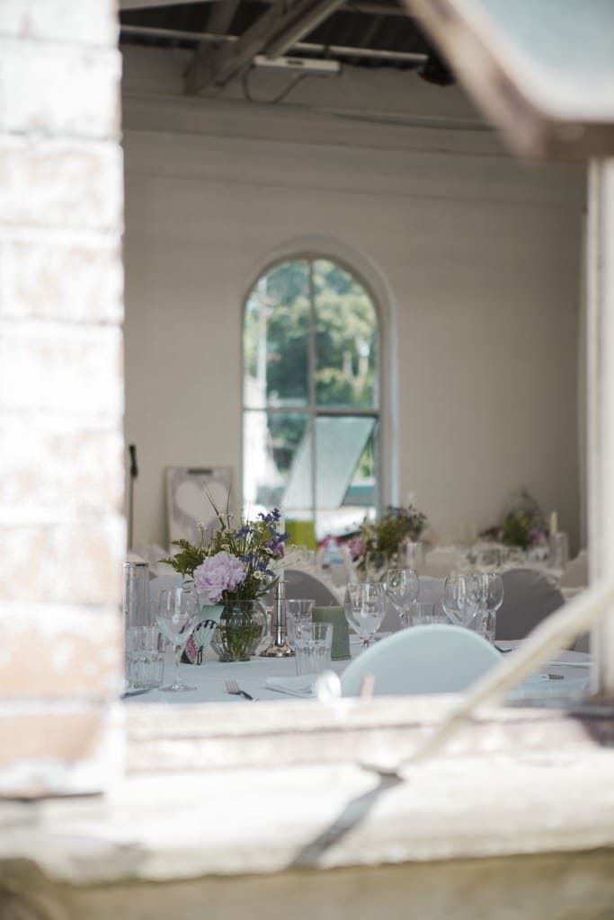 Hochzeitslocation Orangerie Köln: Blick in den Festsaal mit gedeckten Tischen