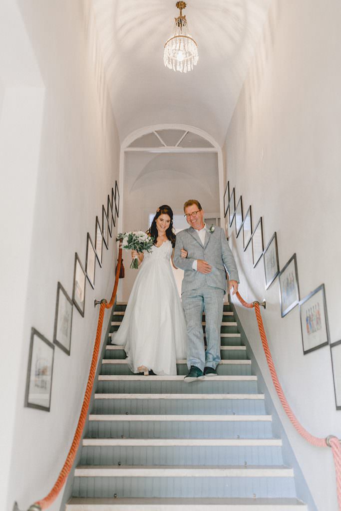 die Braut wird von ihrem Vater eine Treppe herab geführt
