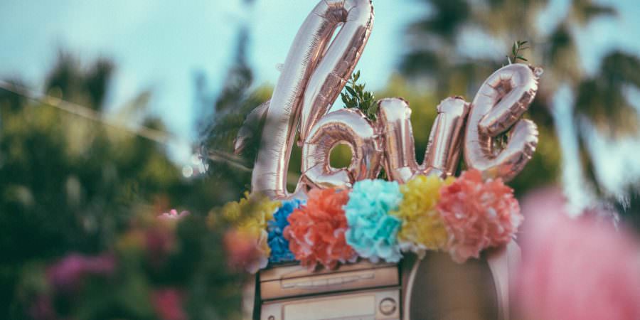 Hochzeitsdeko mit bunten Pompoms und love Ballon