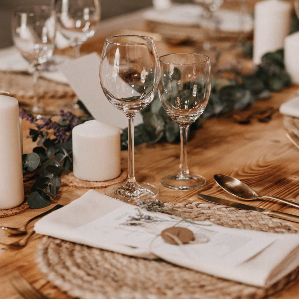 Rustikale Tischdeko einer Scheunenhochzeit mit Eukalyptus und Naturmaterialien