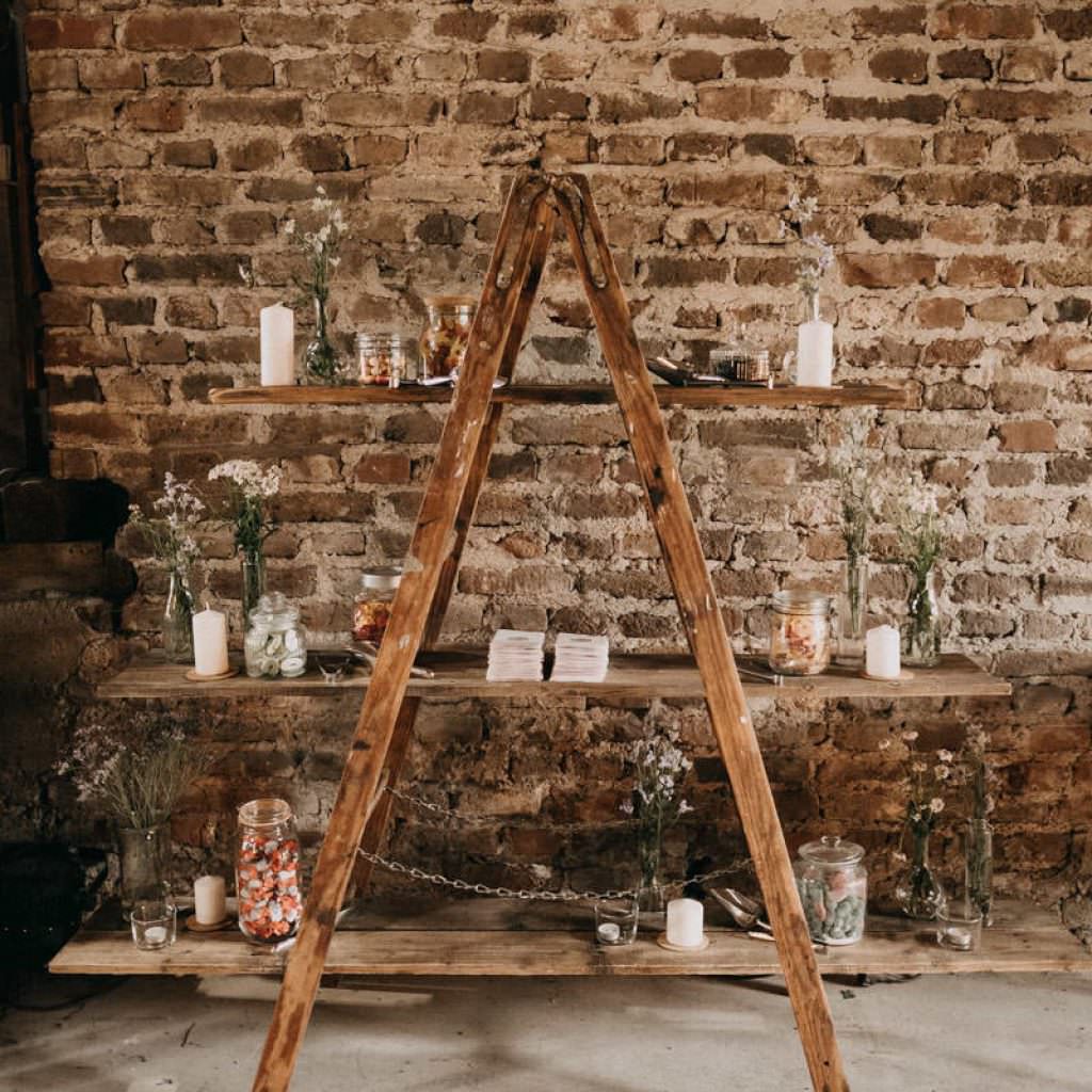 Rustikales Holzregal mit Blumen und Deko bei einer Scheunenhochzeit