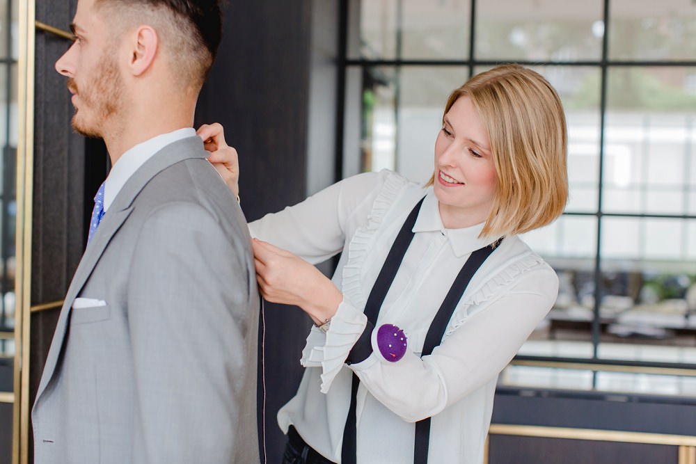 Anna Ullrich-Cattien von The Bloke nimmt vom Bräutigam Maße für einen Hochzeitsanzug