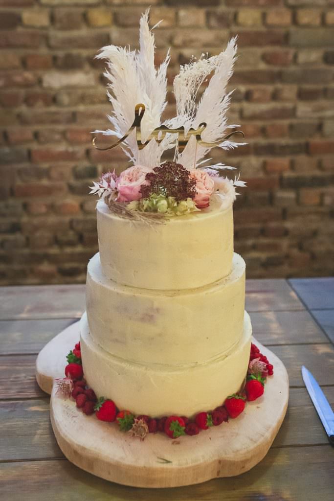 Weiße Hochzeitstorte mit Pampasgras, Blumendeko und love Cake Topper
