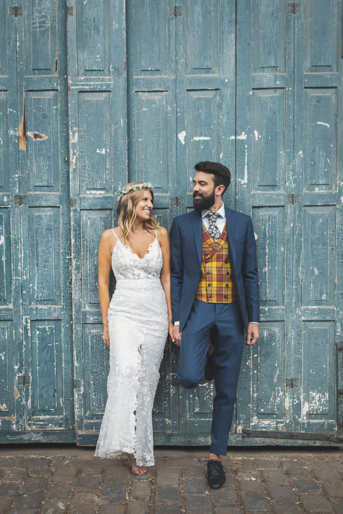 Hochzeitsfotoidee: Braut und Bräutigam lehnen an einer alten, blauen Holztür