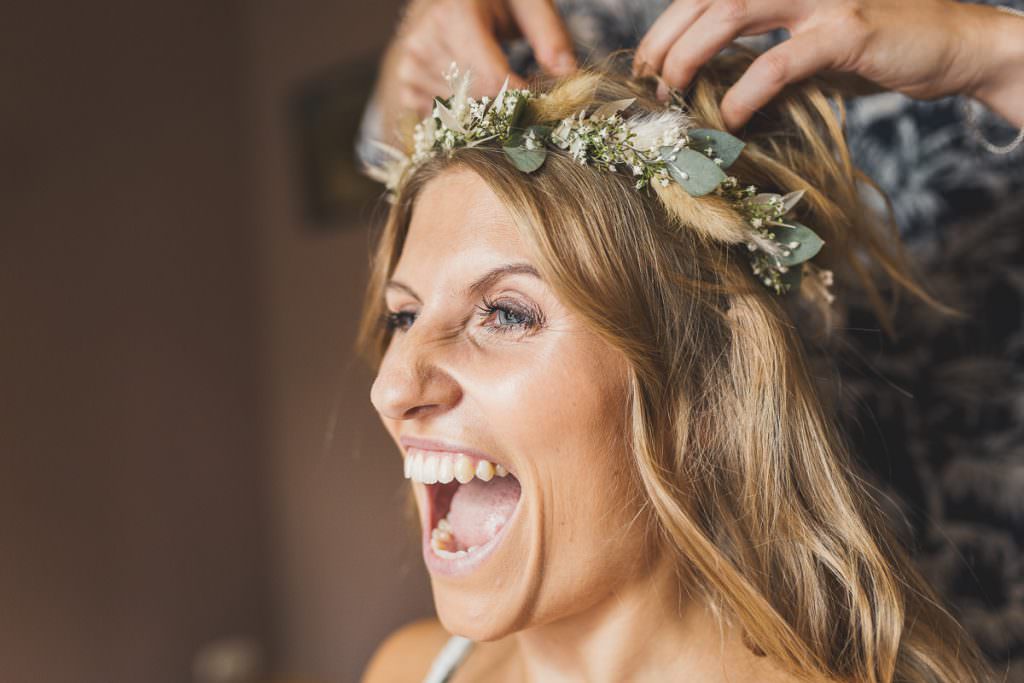 Der Braut wird beim Getting Ready der Blumenkranz ins Haar gesteckt