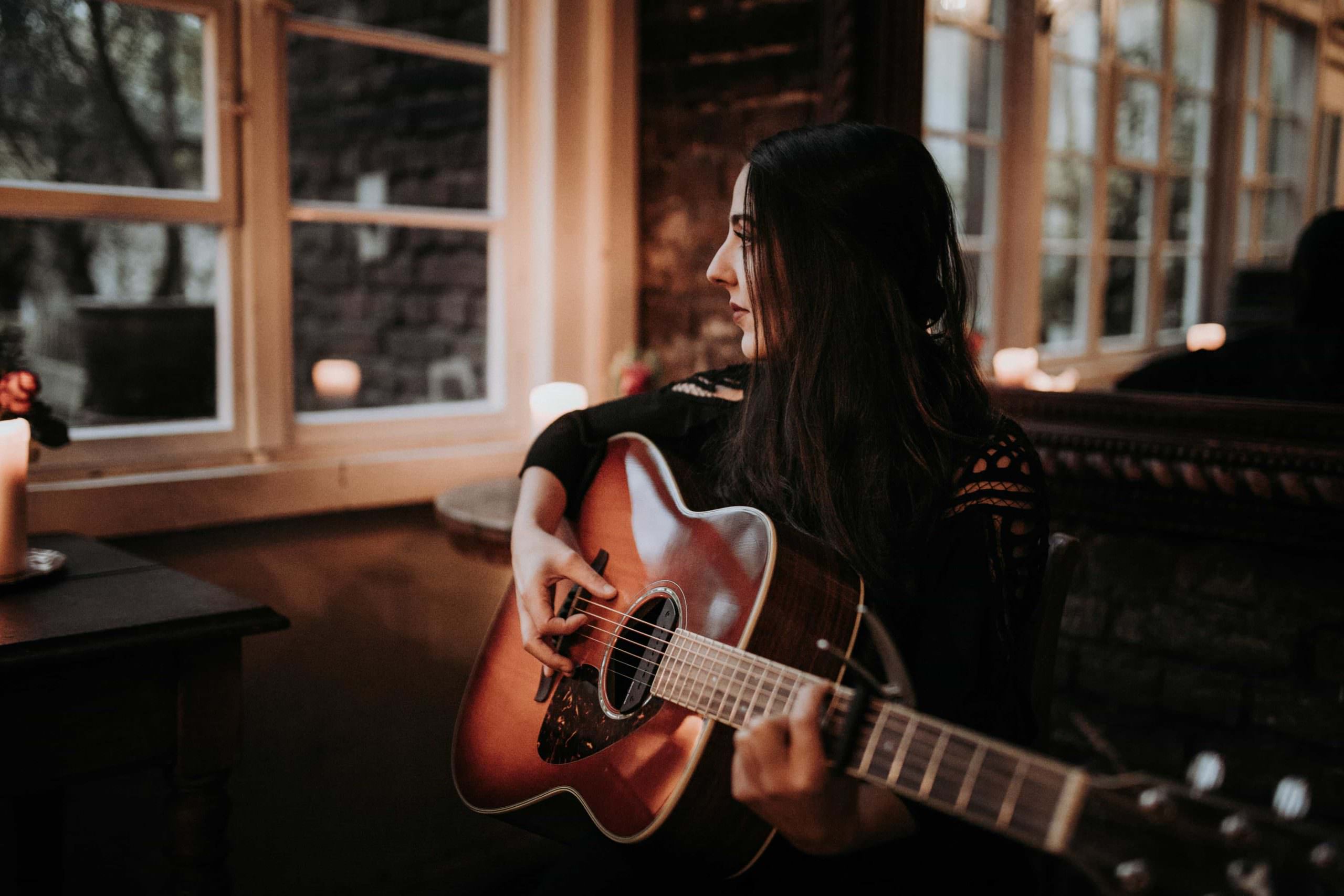 Portrait von Sängerin Jaqueline Rubino mit Gitarre