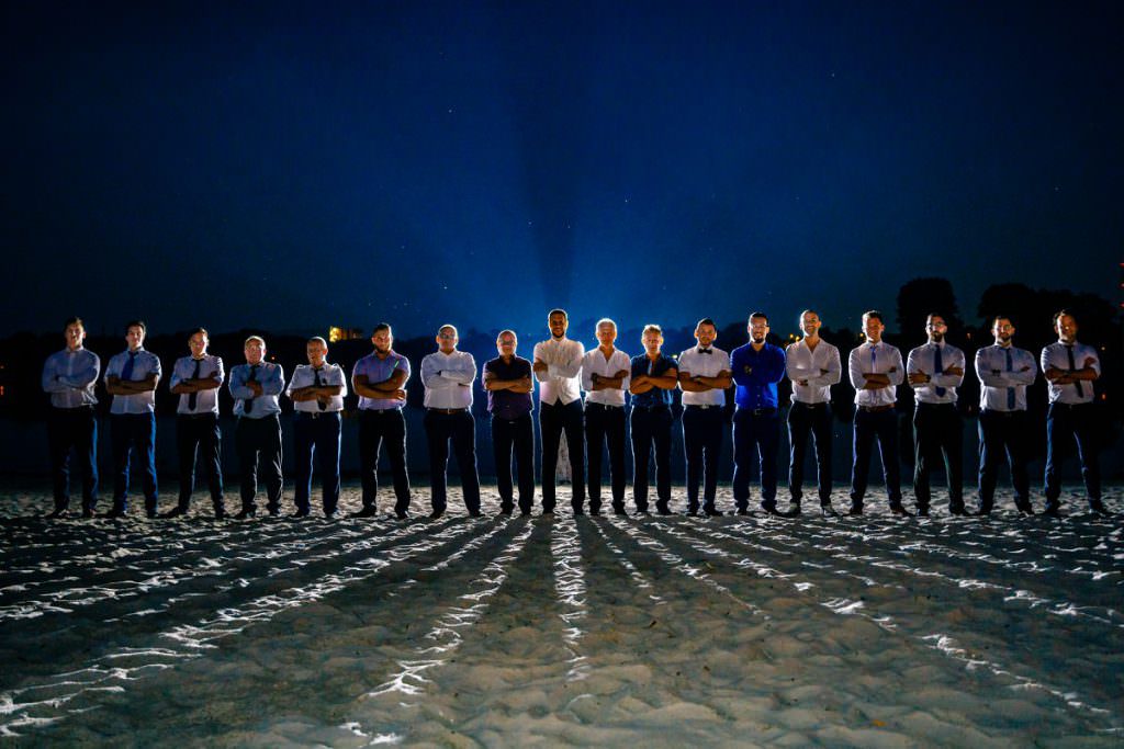 Hochzeitsgruppenfoto mit allen Männern, aufgenommen bei Nacht