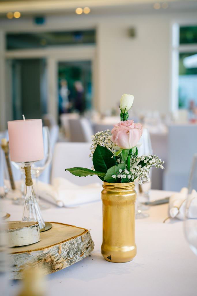 Hochzeitstischdeko im Seepavillon Köln mit Rosen und Schleierkraut in einer Goldvase