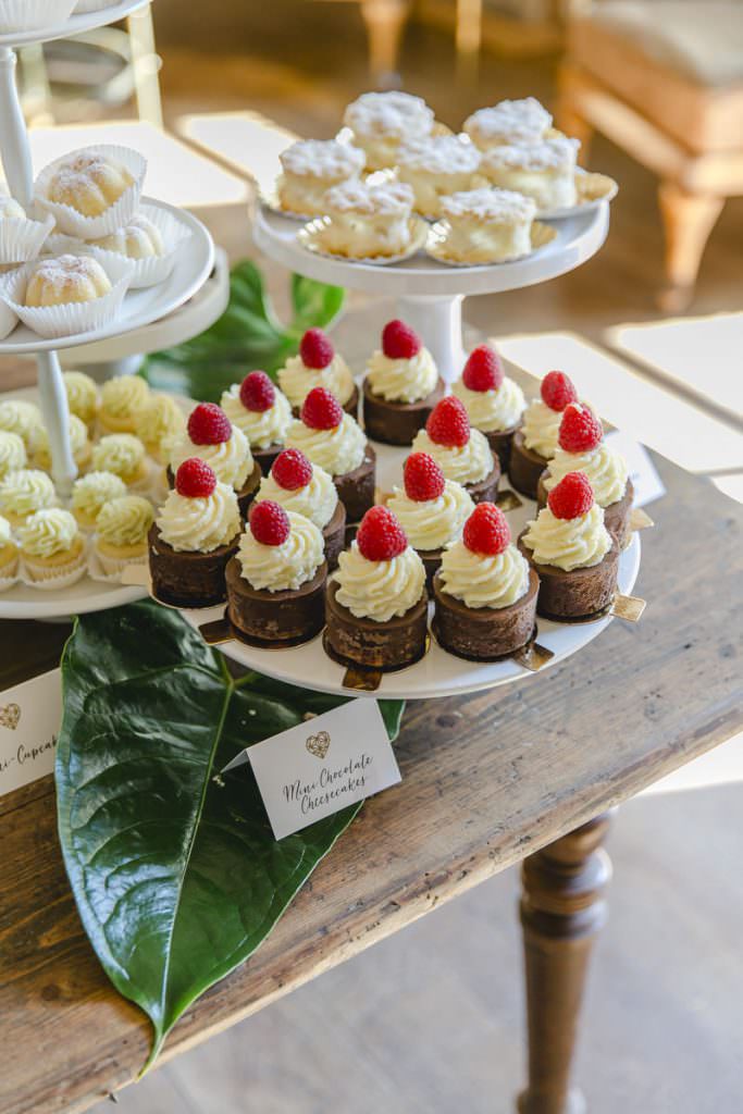 kleine Schokotörtchen mit Sahne und Himbeere auf dem Kuchenbuffet einer Hochzeit