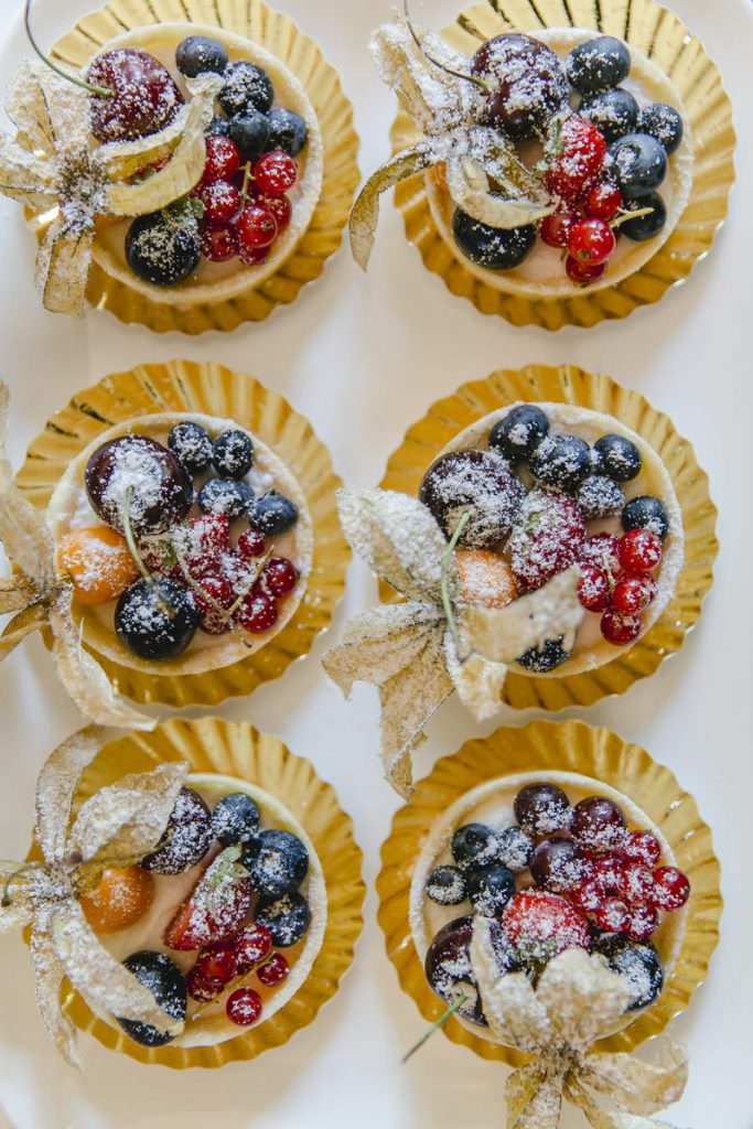 mit Puderzucker bestäubte Obsttörtchen auf dem Kuchenbuffet einer Hochzeit