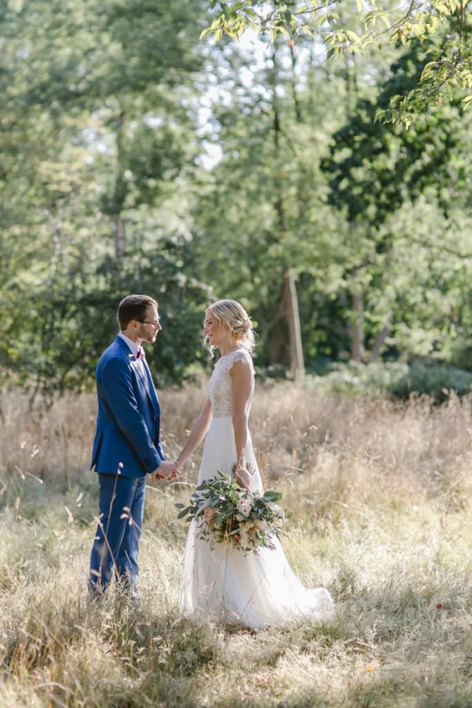 Corona-Hochzeit Rittergut Orr: Romantisches Paarfoto zwischen hohen Gräsern.