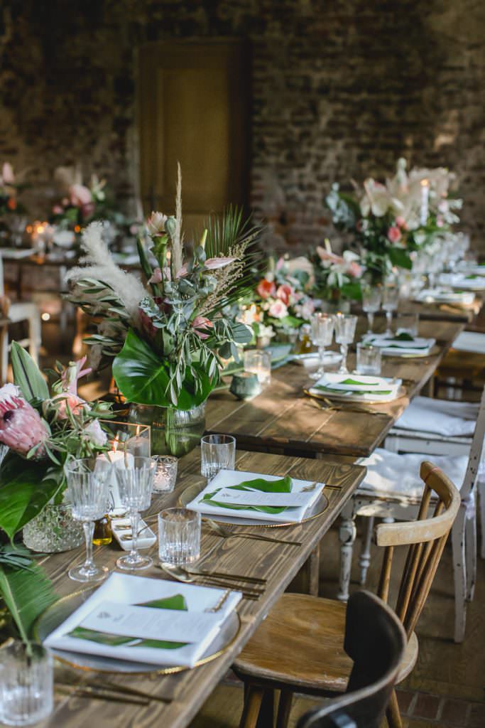 Hochzeitstischdeko mit Eukalyptus, Pampasgras, Protea, Olivenzweigen und Palmenblättern.