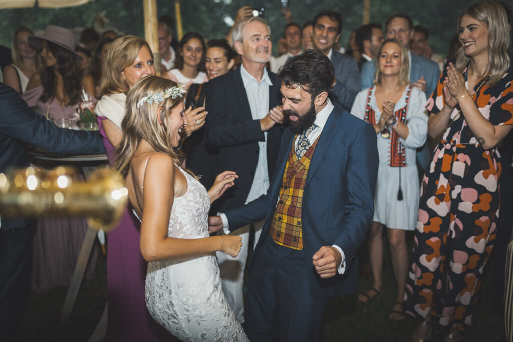 Ein Hochzeitspaar tanzt ausgelassen auf ihrer Hochzeitsparty.