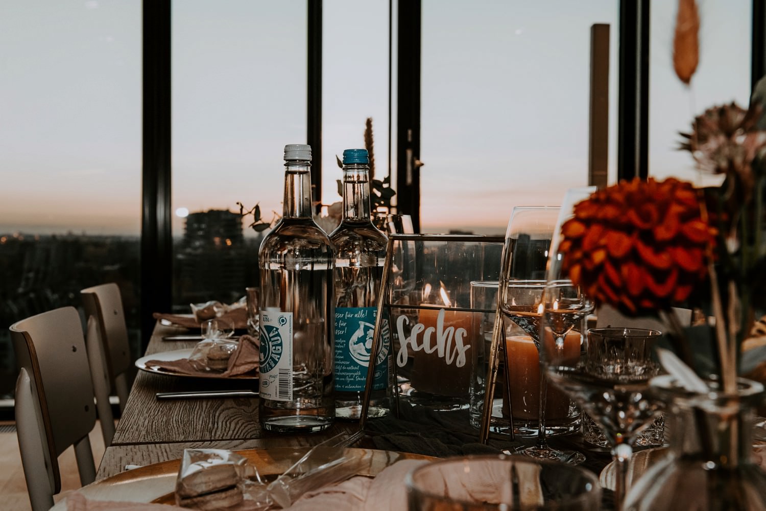 Ein gedeckter Hochzeitstisch mit Blick auf die Skyline von Düsseldorf in den Abendstunden.