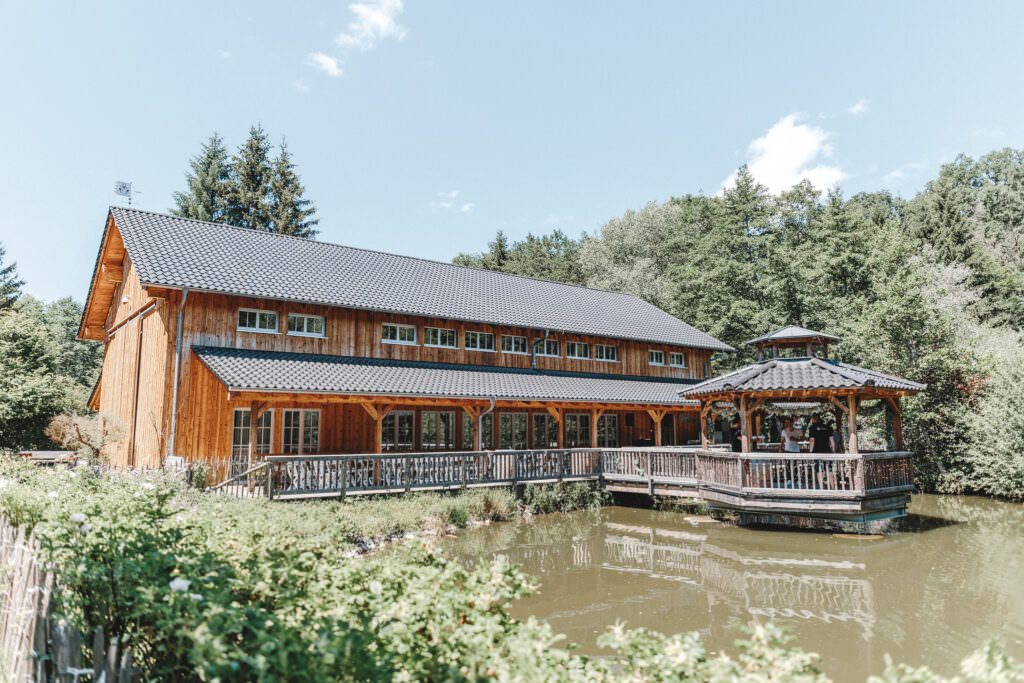 Aussenansicht der an einem See gelegenen Hochzeitslocation Holsteins Mühle mit Pavillon
