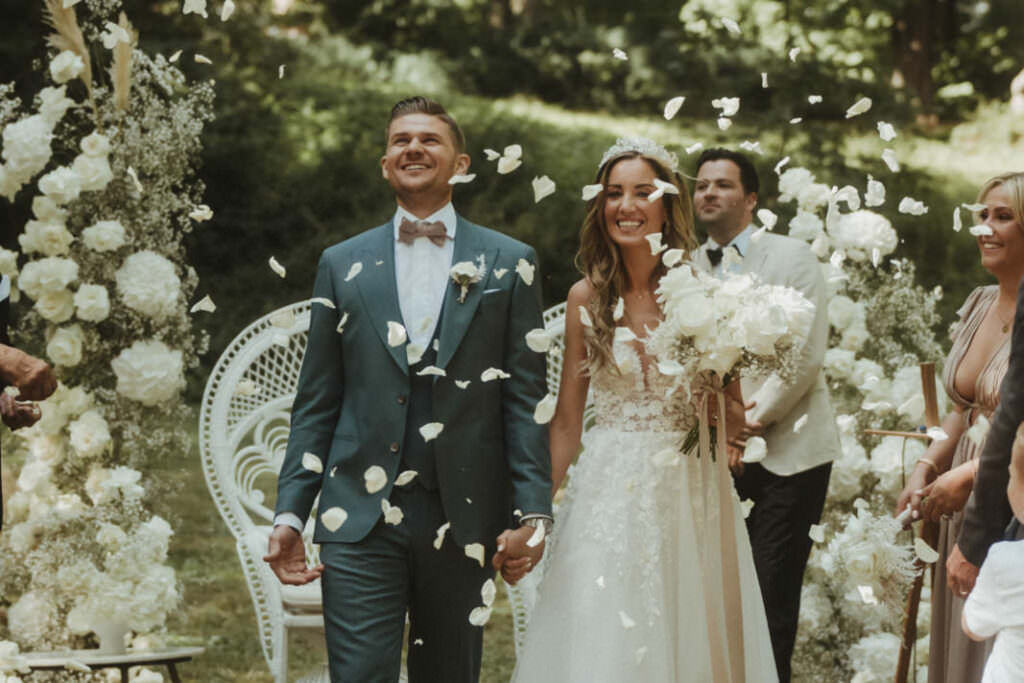 Hochzeitsfoto vom Brautpaar Auszug im Rosenblätter-Regen